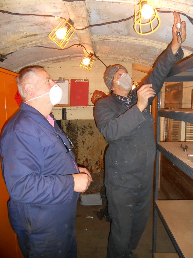 Mike Rigg and John Davis string up lights in the North London Coach storage area