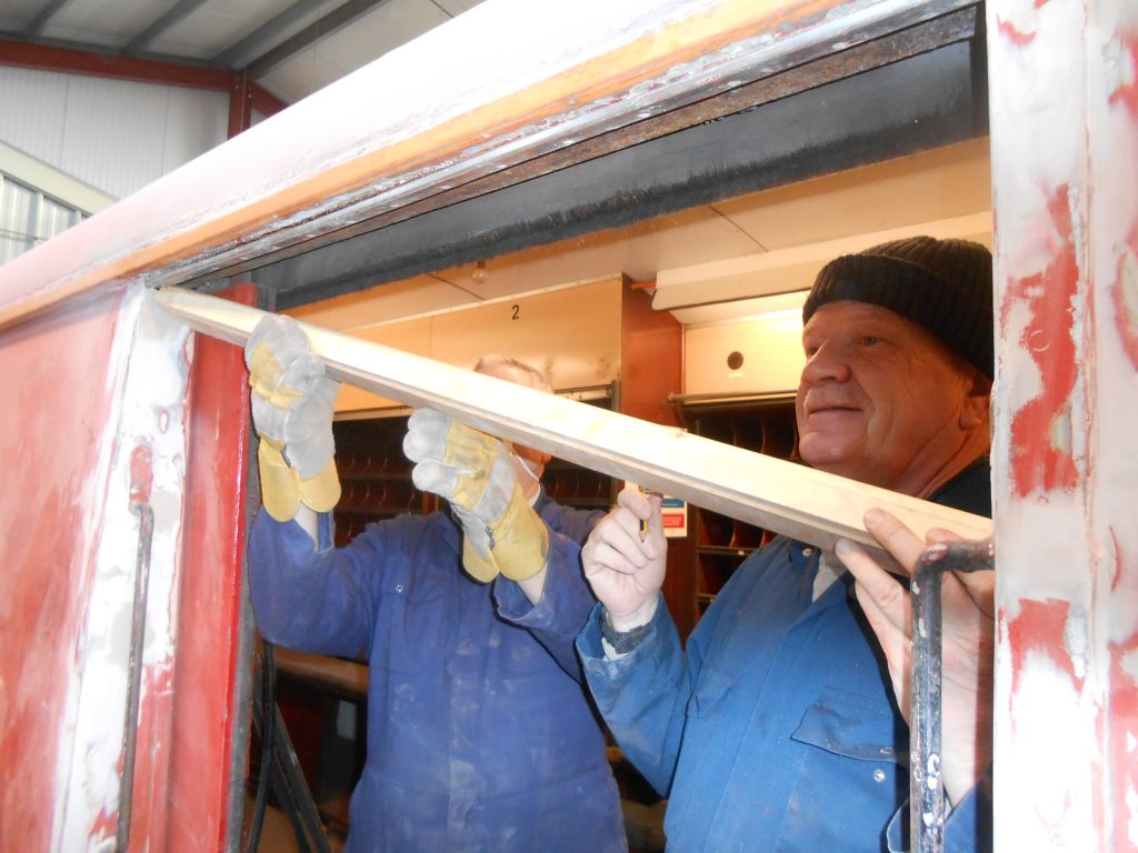 John Davis and Paul Newton fit a new piece of wood above one of the TPO's sliding doors