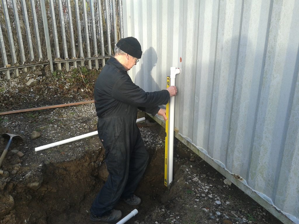 John checks that the new drain pipe stands true