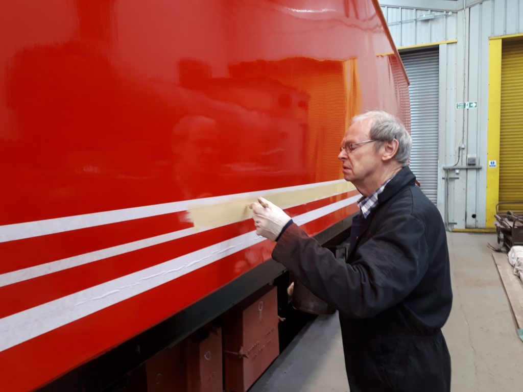 John Dixon concentrates on applying the yellow undercoat