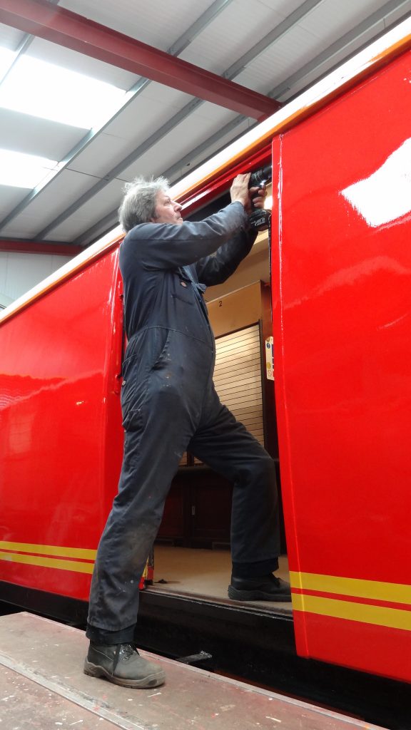 Mike Rigg drills holes so that the brush strips alongside the TPO doors can be fixed