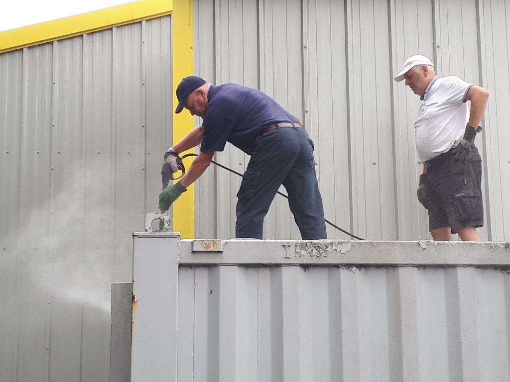 Paul Newton cleans the mess room roof watched by John Davis