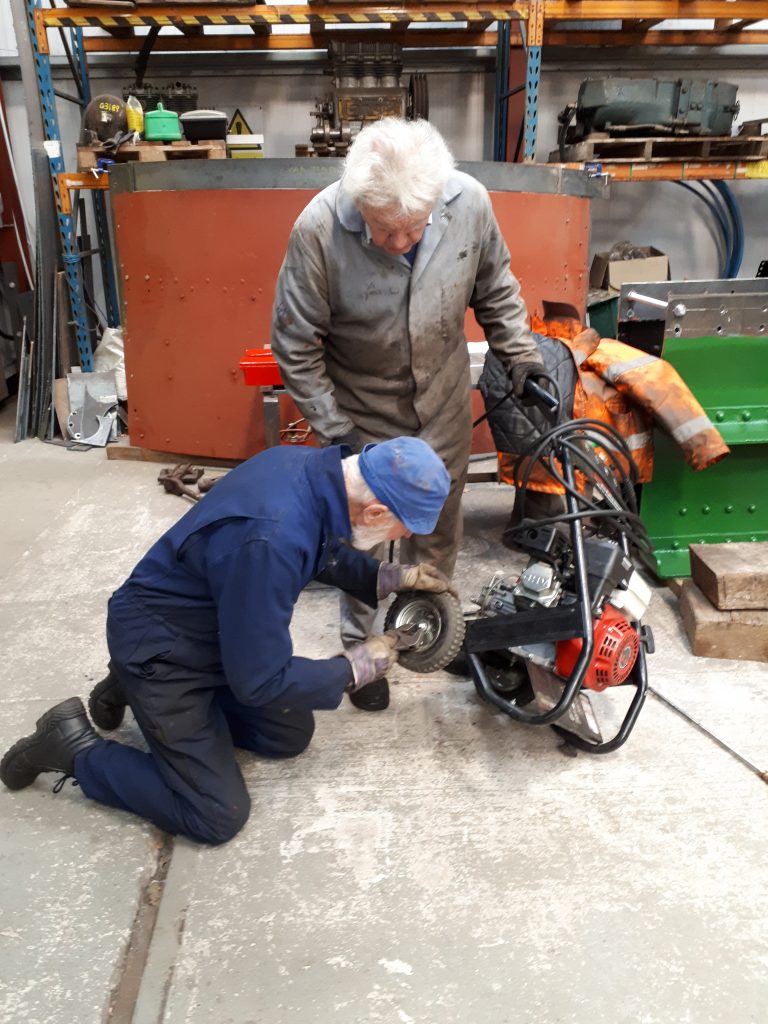 Roger attends to the water pump with assistance from Fred