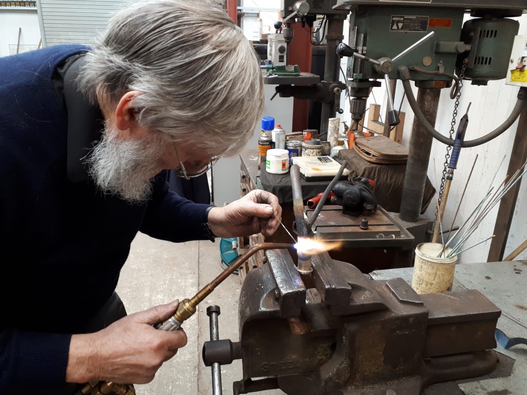 Alan silver soldering a joint on one of Cumbria's brake valve pipes