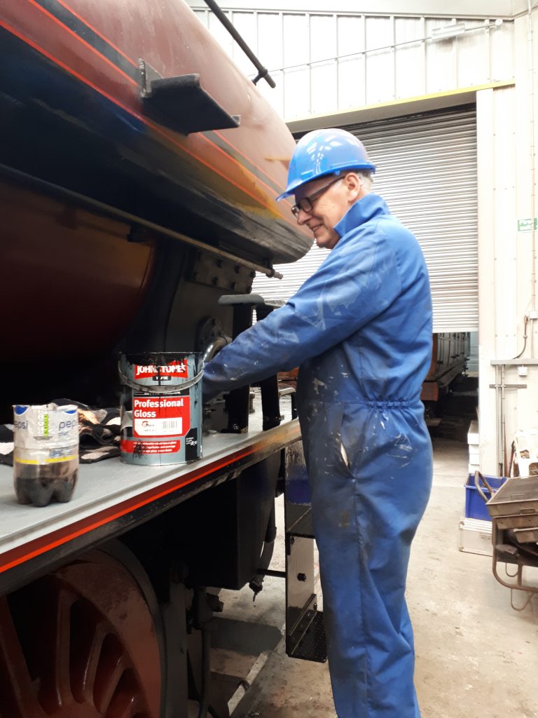 Phil Scales applies a coat of black paint to Cumbria's running board.