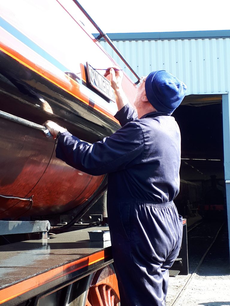 Phil Bell touches up the paint on Cumbria's nameplate