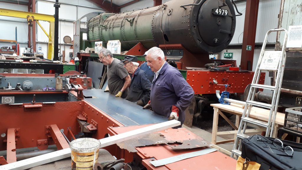 A new running board plate is lifted into position on Fluff