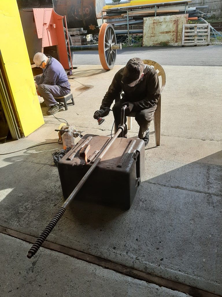 Fred cleaning up FR 20's hand brake with John Davis on the left