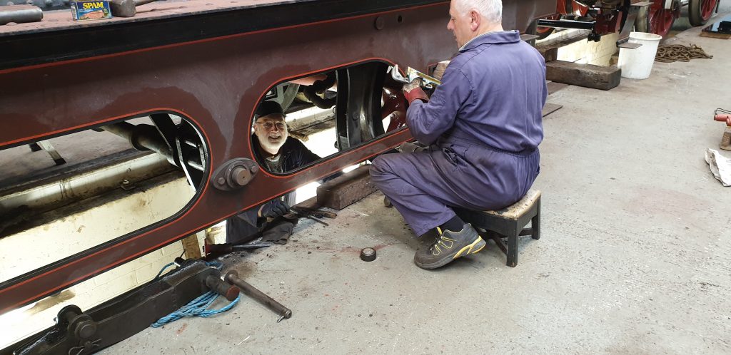 Phil Bell and John Davis work to remove a brake hanger on FR 20's tender