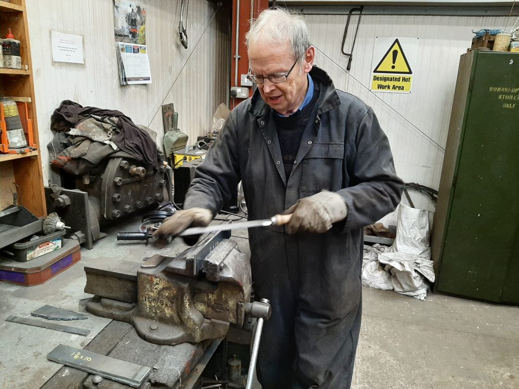 John Dixon prepares a piece of steel prior to forming it into a vacuum pipe bracket