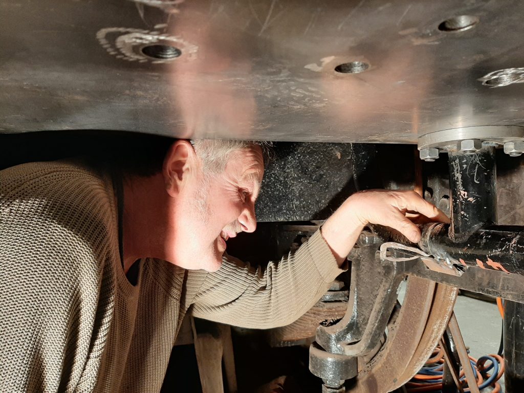 Keith fitting a new vacuum pipe beneath Wootton Hall's cab floor