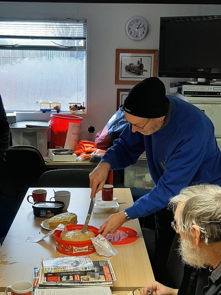 Alan watches as David Rimmer cuts one of the birthday cakes