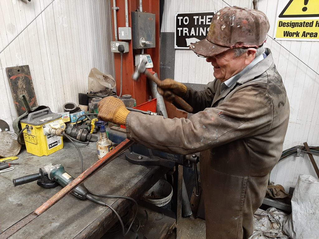 Fred wielding a hammer to a stubborn sand box linkage