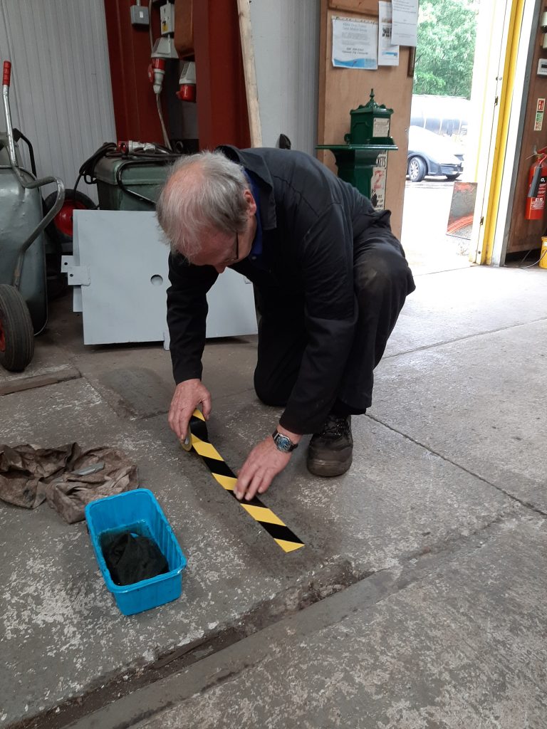 John Dixon laying adhesive tape