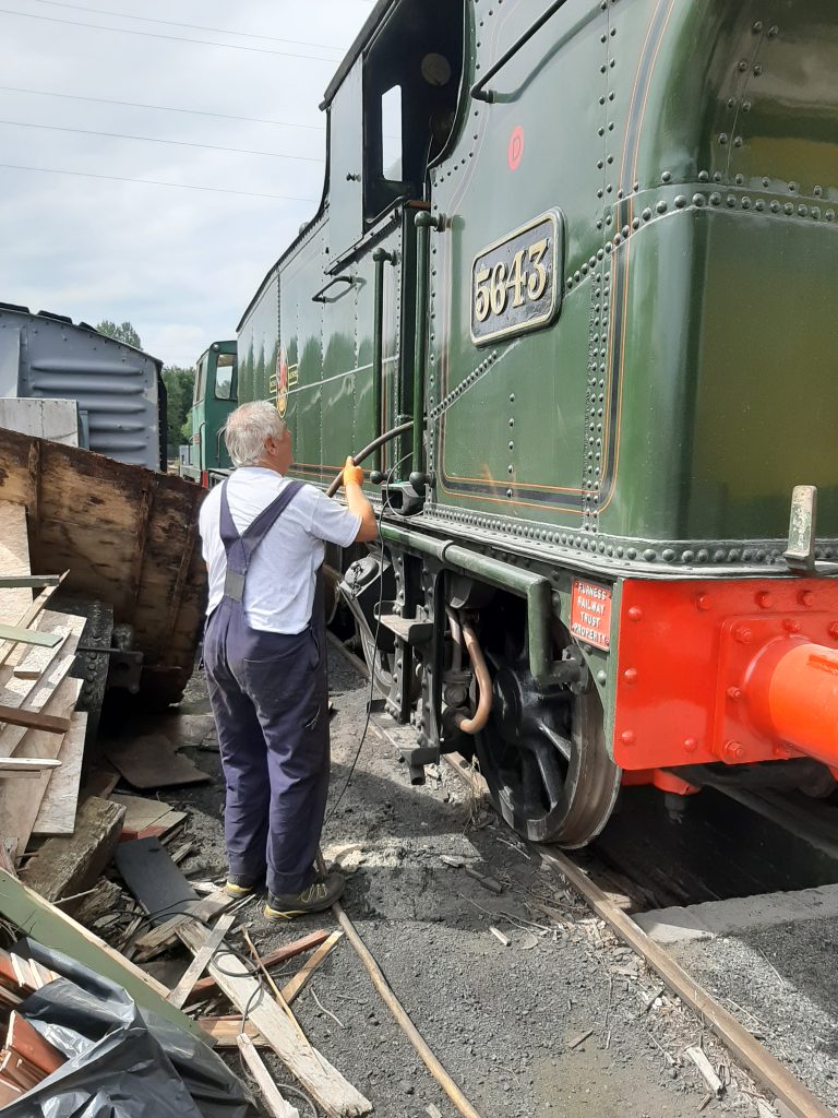 John Davis feeds a water pipe into the cab of 5643