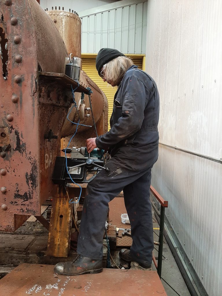 Ade sets up the magnetic drill on Caliban's smokebox