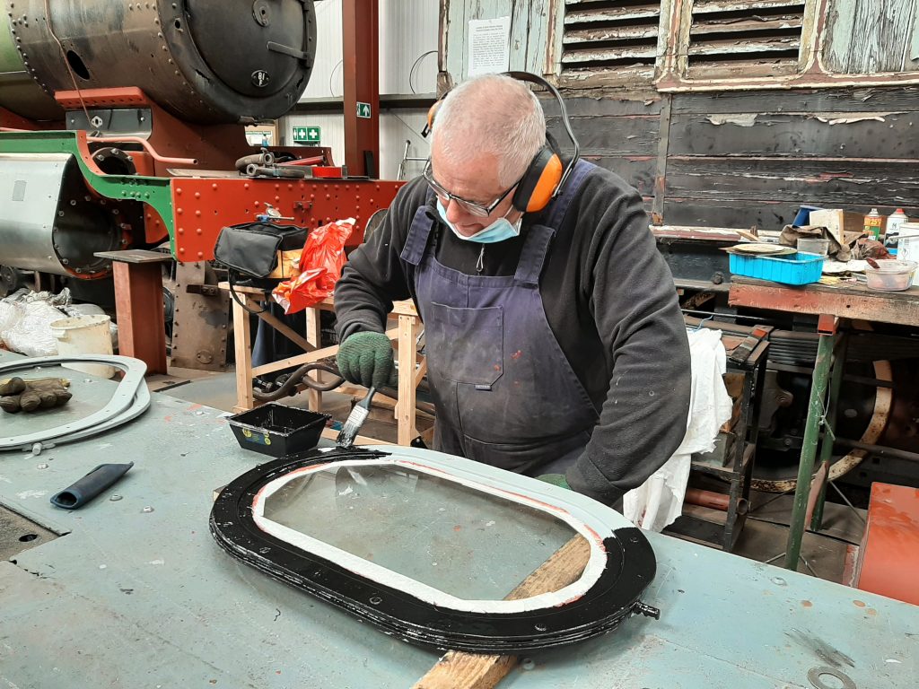 John Davis painting one of Fluff's cab windows