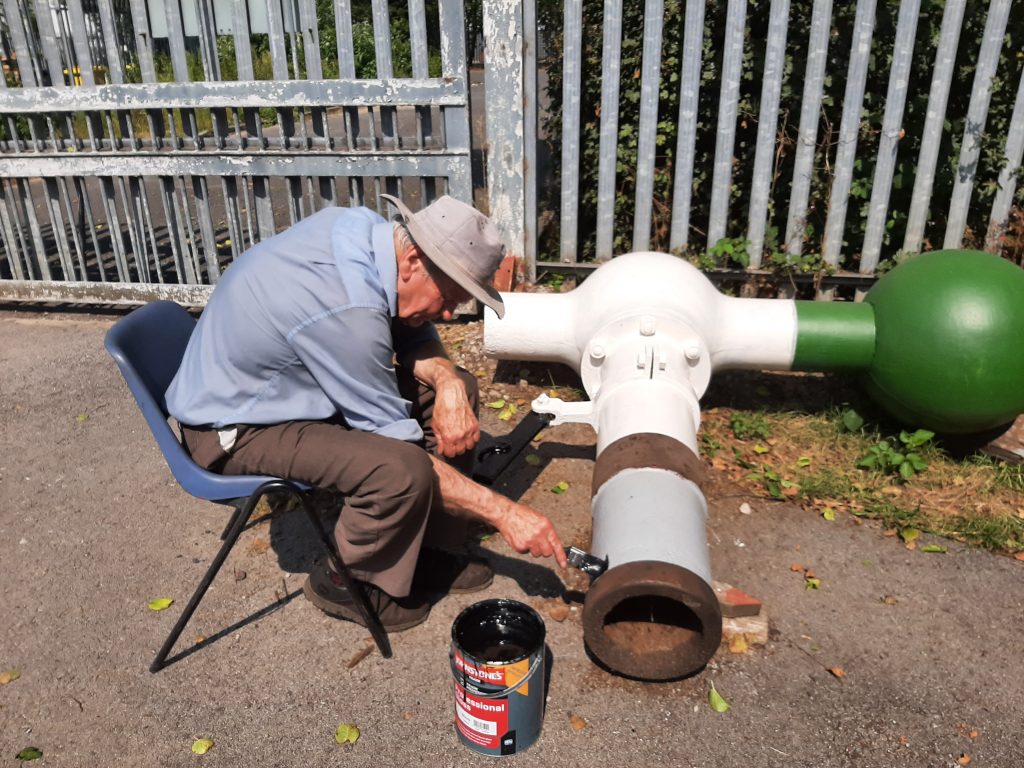 Fred painting the water column in the heat of the sun