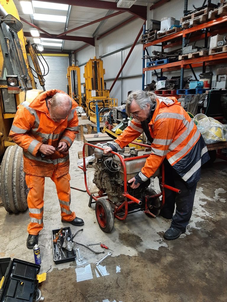 Neil Glover cleans the fuel stop valve whilst Ade performs the vital task of stooping the fuel flowing from the tank!