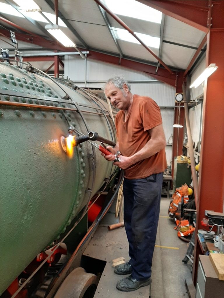 Keith warmmng up a handrail stanchion in order to remove it so that boiler cladding can be fitted