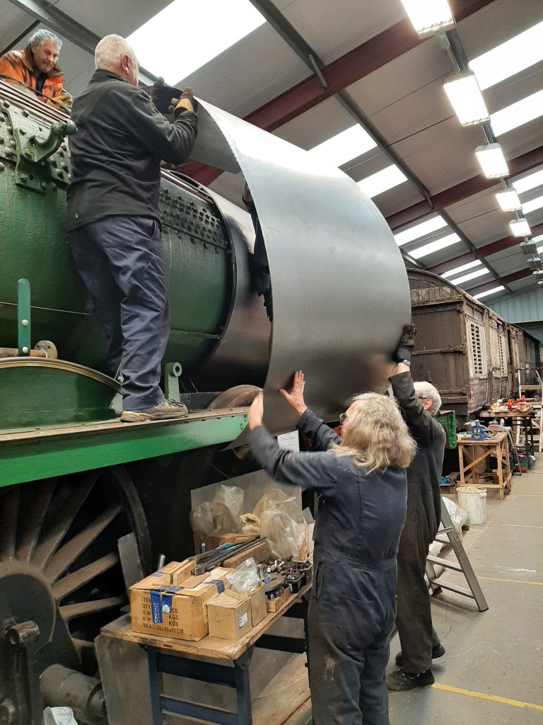 The third right hand cladding sheet goes on Wootton Hall's boiler