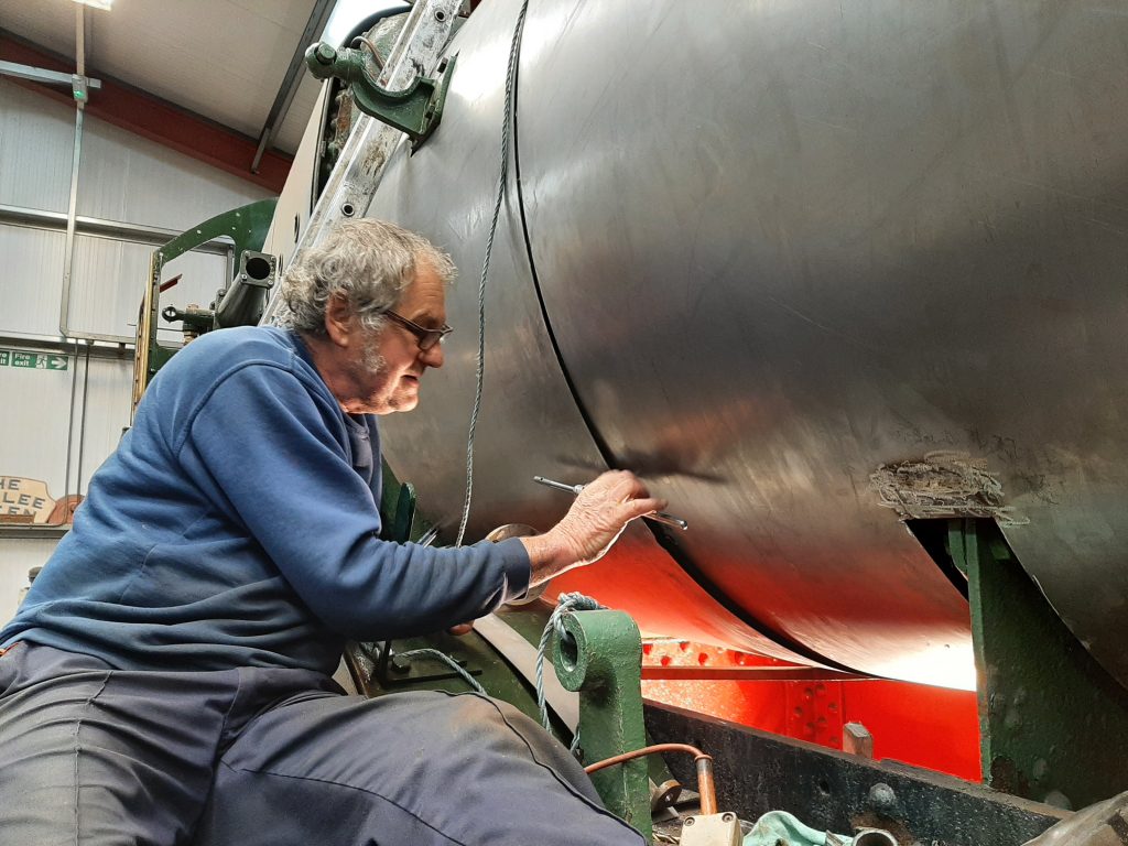 Keith tapping a hole in Wootton Hall's cladding