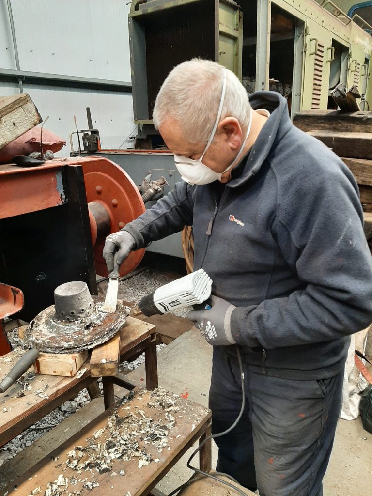 John Davis cleaning paint off the gas lamp housings