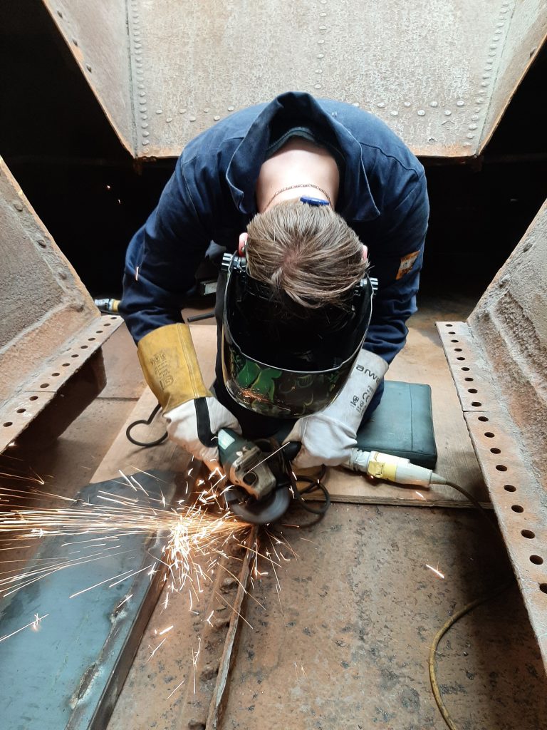 Matthew Owen grinding old steelwork in readiness for inserting a new steel plate.