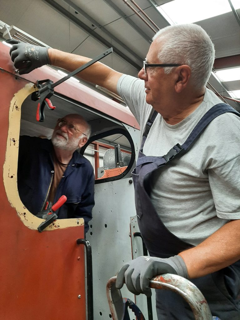 Phil Bell watches as John Davis fits a bolt to Fluff's new roof