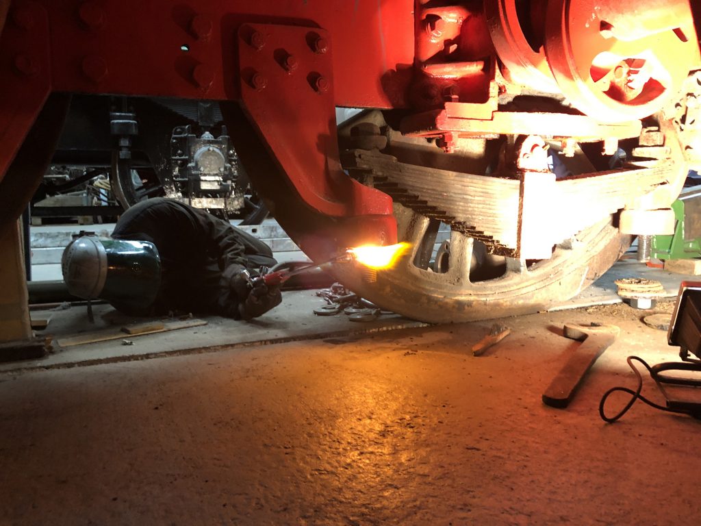 George applying heat to a recalcitrant nut on one of Wootton Hall's spring hangers