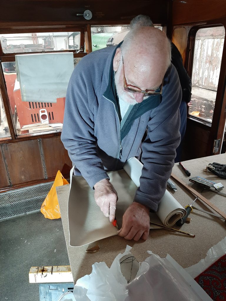 Phil Bell cutting backing sheets for the new fabric lining GER No. 5's interior walls.