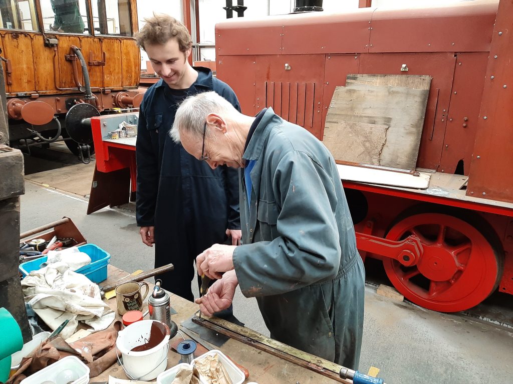 Sam watches on whilst John Dixon repairs a window support for GER 5