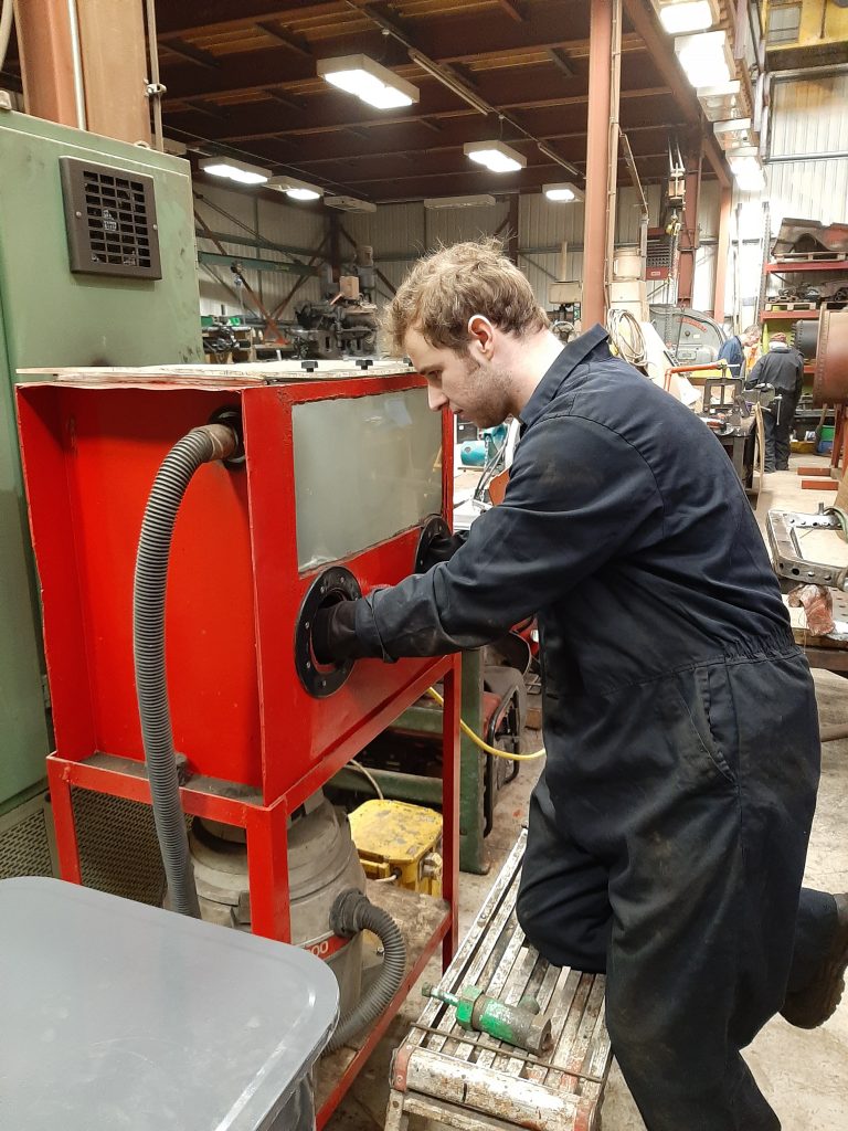 Sam at work with the sand blasting booth