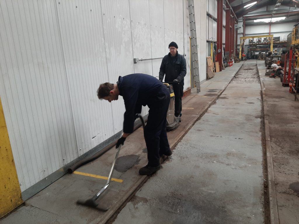 Sam and John Dixon cleaning the shed floor
