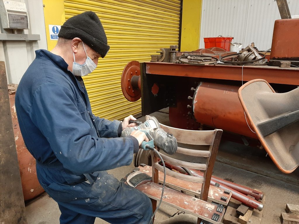 Phil Burton sanding a donated chair