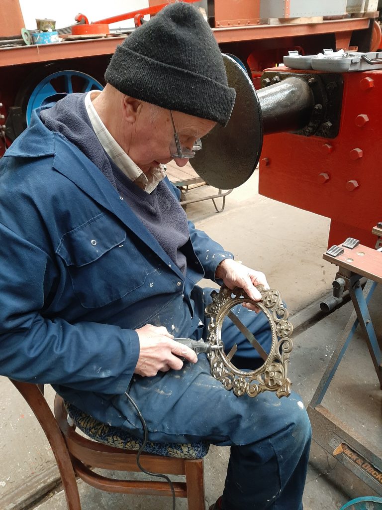 Phil Burton giving one of the picture frames a polish