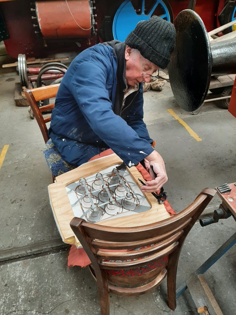 Phil Burton prepares one of GER 5's seats to receive a temporary brown cover