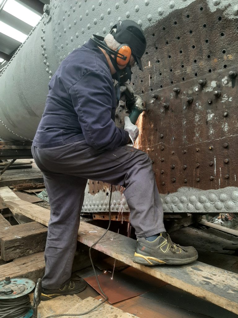 John Davis grinding off more stay heads on 5643's firebox