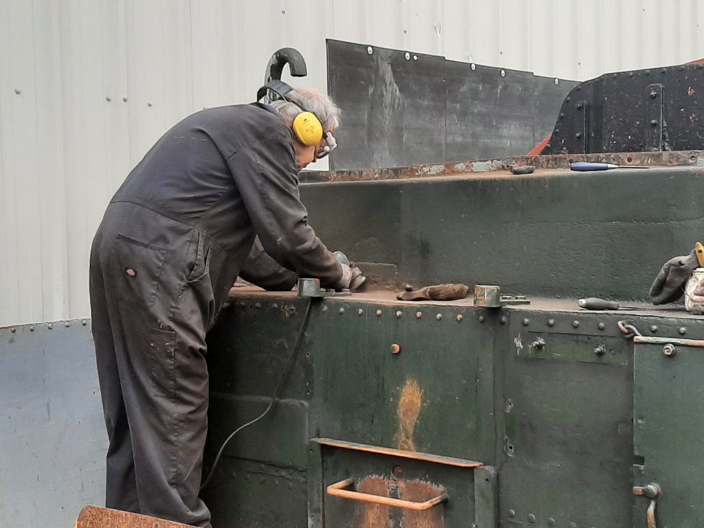 John Dixon cleaning 5643's bunker of rust and old paint
