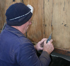 Trevor Bradshaw routing a crack in the external panelling ready for filling with a mix of cascamite and teak sawdust